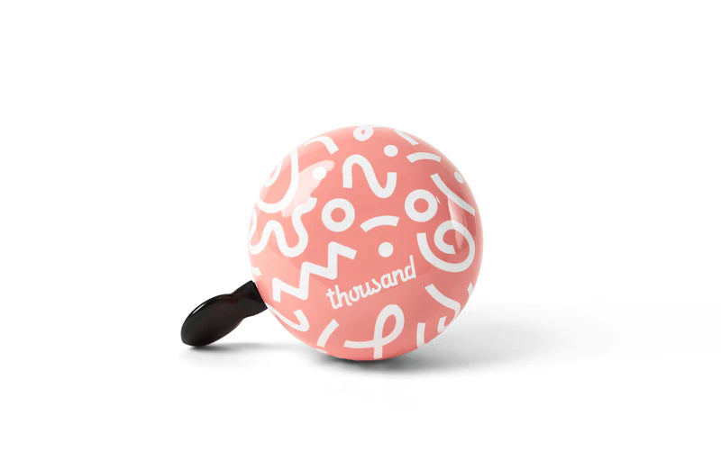 pink thousand kids bicycle bell with white squiggle shapes
